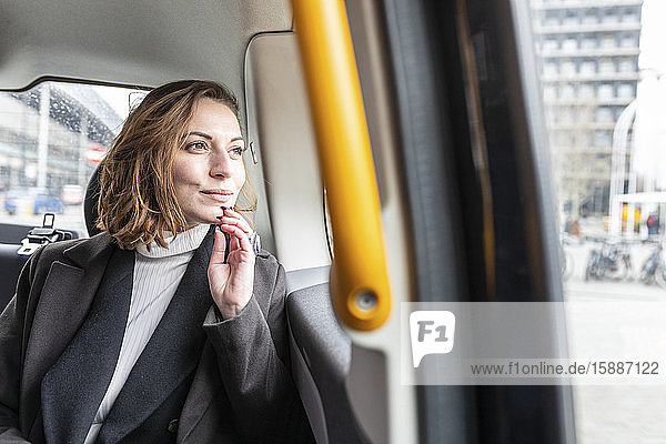 Woman in the rear of a taxi looking out of the window  London  UK