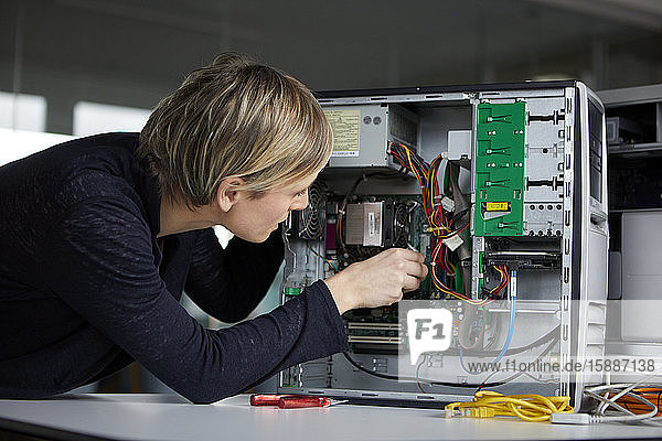 Frau beim Zusammenbau eines Desktop-PCs im Büro