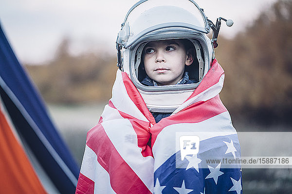 Bildnis eines kleinen Jungen mit amerikanischer Flagge und Weltraumhelm