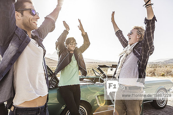 Glückliche Freunde im Cabriolet auf einer Autoreise