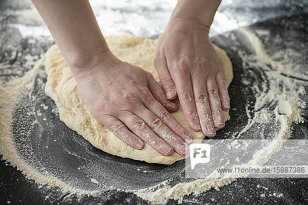 Woman's hands kneeling dough on worktop  close-up