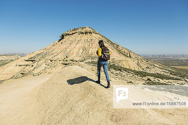 Woman walking in desertic landscape of Bardenas Reales  Arguedas  Navarra  Spain