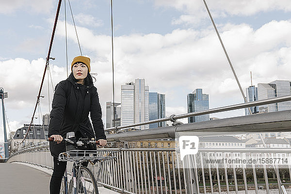 Frau fährt Fahrrad auf einer Brücke  Frankfurt  Deutschland