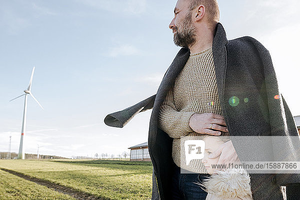 Father and little daughter on a field in winter