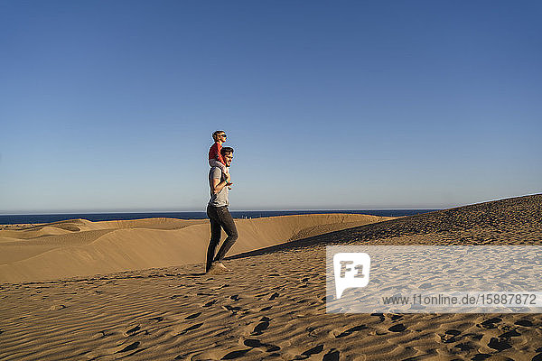 Vater trägt Tochter auf Schultern in Sanddünen  Gran Canaria  Spanien