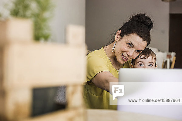 Mutter und ihr kleiner Junge während eines Videoanrufs am Laptop zu Hause