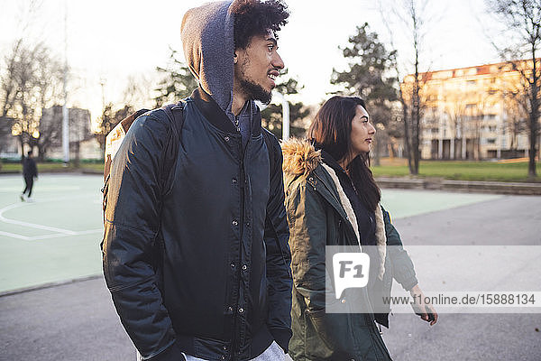 Young couple walking at basketball court