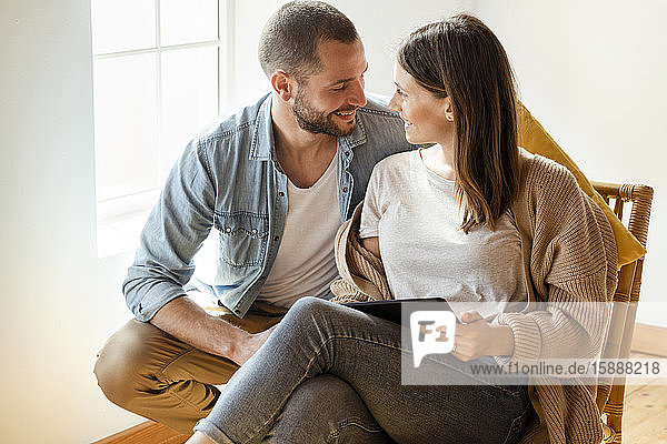 Happy couple at home in front of window looking at each other