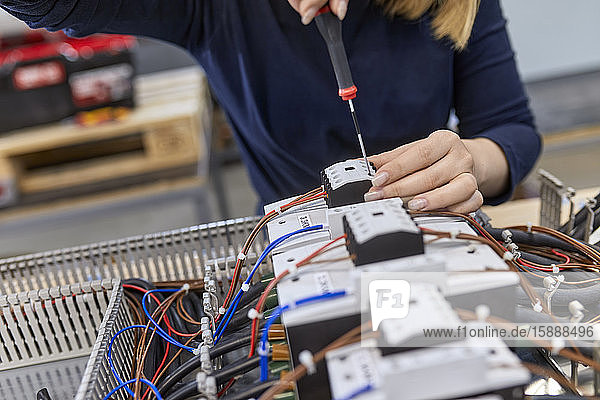 Nahaufnahme eines Elektrikers  der in einer Werkstatt an Schaltkreisen arbeitet