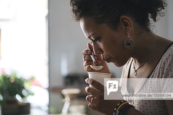 Woman working in a coffee roastery tasting product