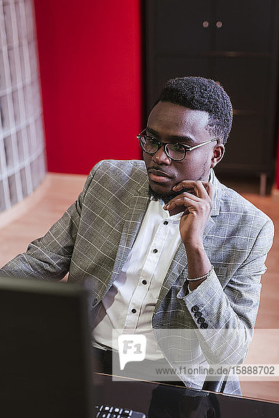 Portrait of young businessman at desk in office