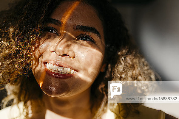 Porträt einer glücklichen jungen Frau im Sonnenlicht