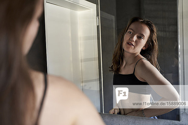 Spiegelbild eines Mädchens  das sich selbst im Badezimmer beobachtet