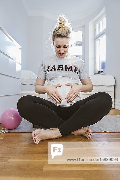 Schwangere Frau übt zu Hause mit einem Ball
