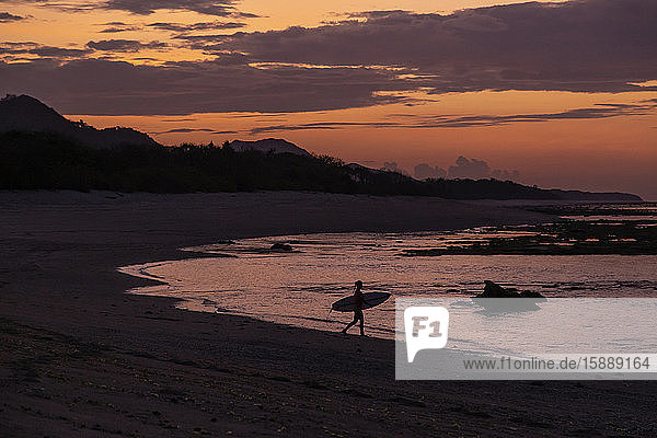 Indonesia Sumbawa Silhouette of female surfer at late dusk