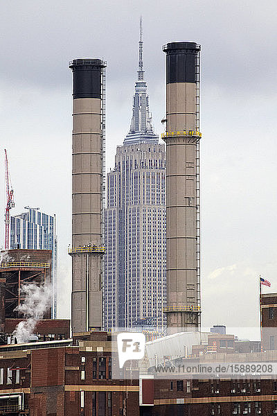USA  New York  New York City  Empire State Building zwischen zwei Fabrikschornsteinen gesehen