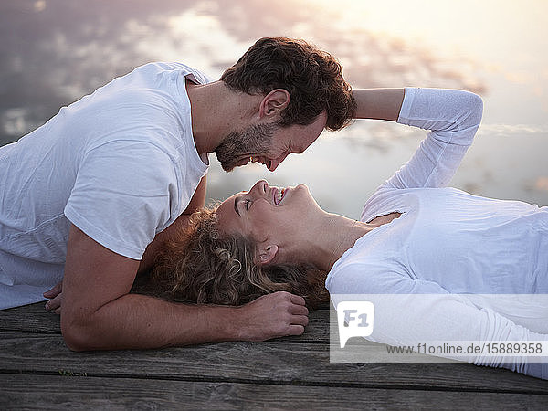 Romantisches Paar liegt auf dem Steg und küsst sich