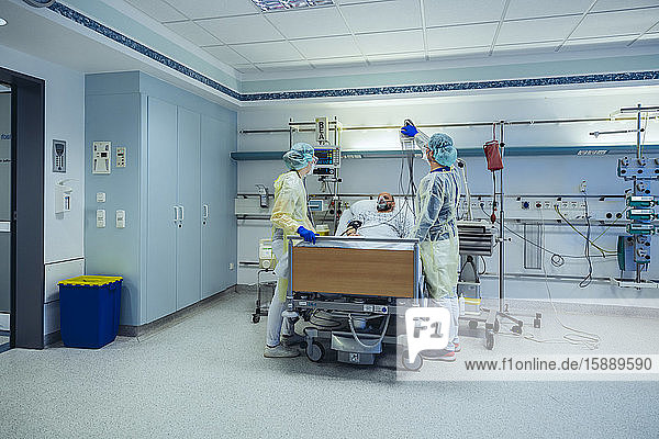 Ärzte  die Patienten auf der Notfallstation eines Krankenhauses mit Beatmungsgeräten versorgen