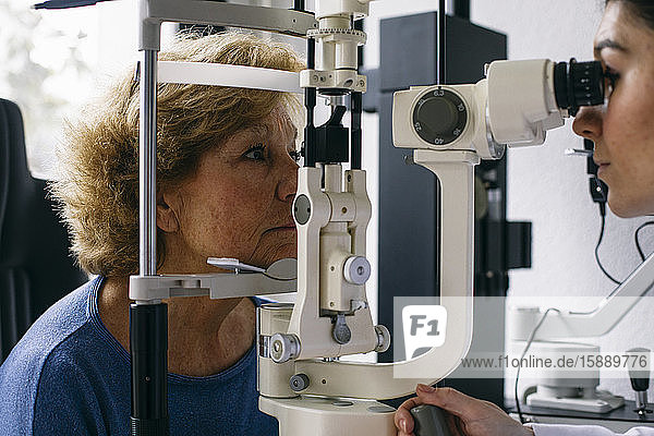 Augenarzt  der das Sehvermögen eines älteren Patienten untersucht