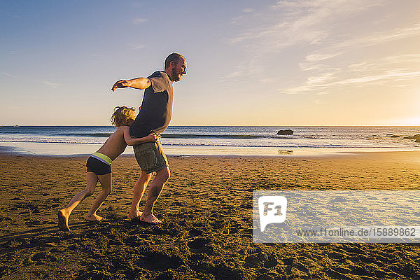 Vater und Sohn beim Spielen und Laufen am Strand