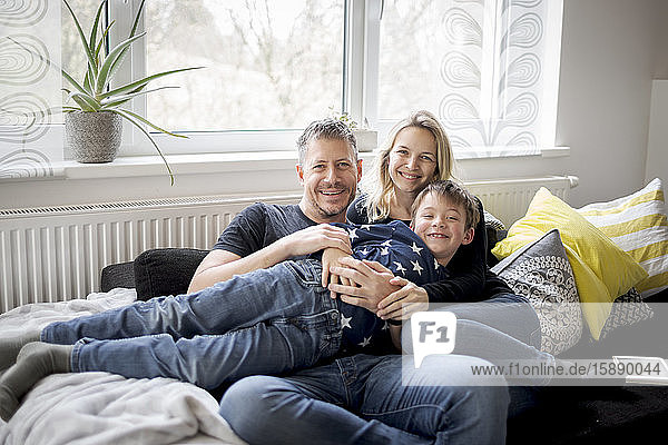 Portrait of happy family relaxing on couch at home