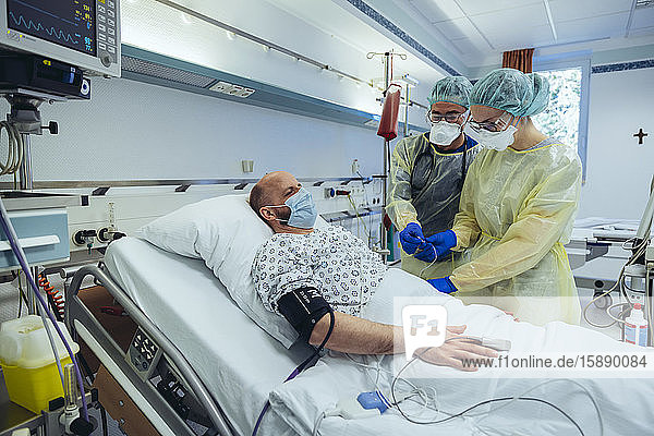 Ärzte die Patienten auf der Notfallstation eines Krankenhauses betreuen und Blutproben entnehmen