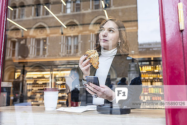 Geschäftsfrau bei einem Imbiss in einem Café in der Stadt