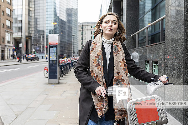Frau in der Stadt mit Leihfahrrad  London  UK