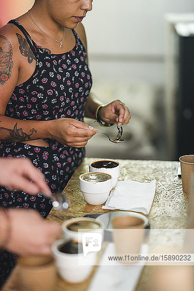 Frau  die in einer Kaffeerösterei arbeitet und Kaffee zubereitet