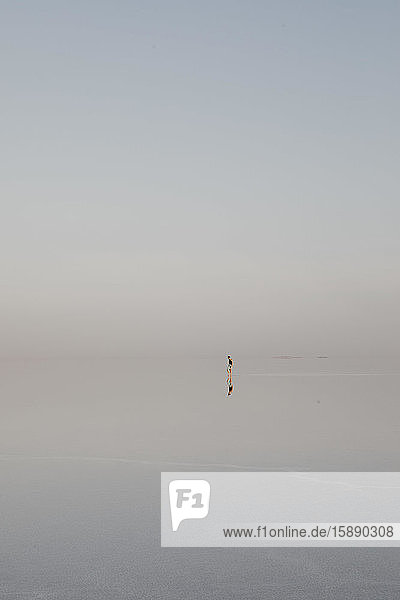 Distant view of woman standing at Lake Karum Danakil Depression Ethiopia Afar