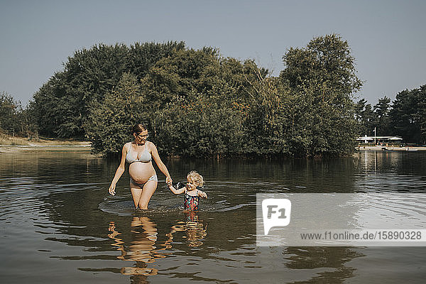 Niederlande  Schiermonnikoog  schwangere Mutter mit Tochter in einem See