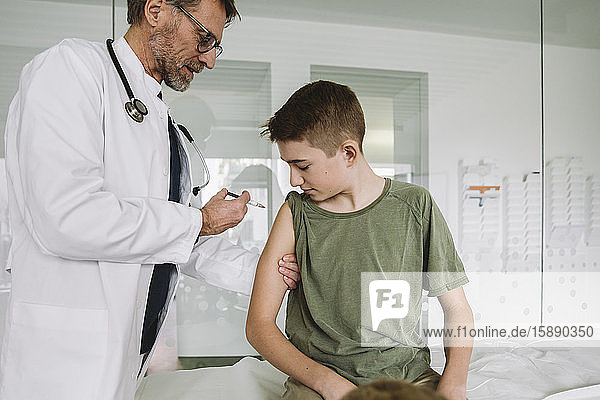 Doctor injecting a vaccine into teenager?s arm