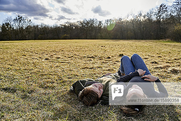 Brother and sister lying on a meadow