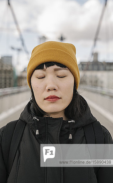 Bildnis einer Frau mit geschlossenen Augen auf einer Brücke