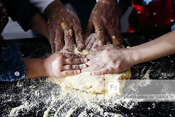 Close-up of hands preparing dough in kitchen at home