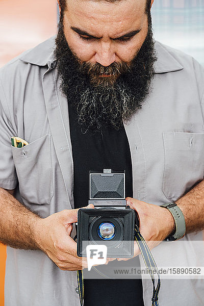 Bearded man taking photo with camera