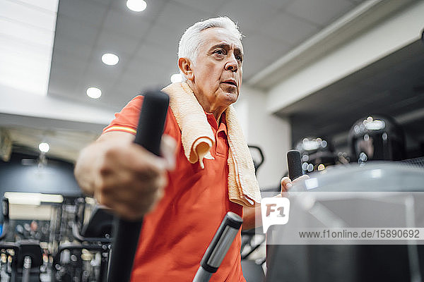 Älterer Mann übt beim Stepper im Fitnessstudio