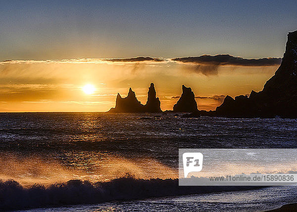 Island  Silhouetten von Reynisdrangar-Seestapeln bei stimmungsvollem Sonnenuntergang