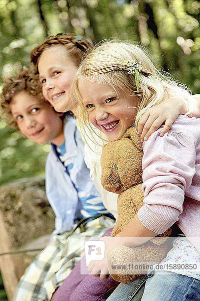 Glückliche Kinder umarmen sich im Wald
