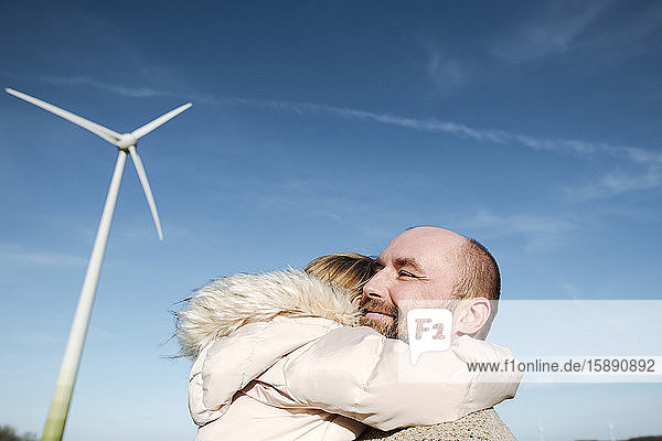 Happy father with his little daughter against sky