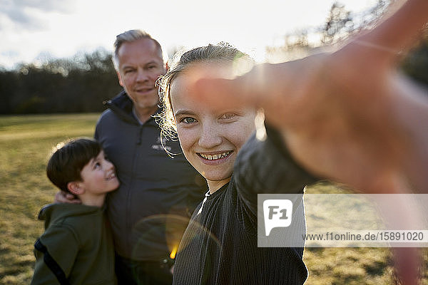 Portrait of happy girl with her family on a meadow