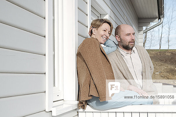 Happy couple talking on porch of their house