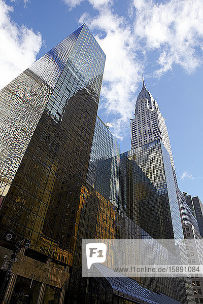 USA,  New York,  New York City,  Niedrigwinkelansicht eines hohen Wolkenkratzers mit dem Chrysler Building im Hintergrund