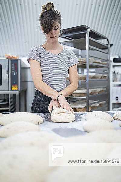 Frau bereitet Brot in Bäckerei zu