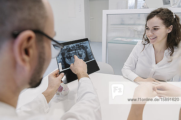 Zahnarzt spricht mit dem Patienten über Röntgenergebnisse