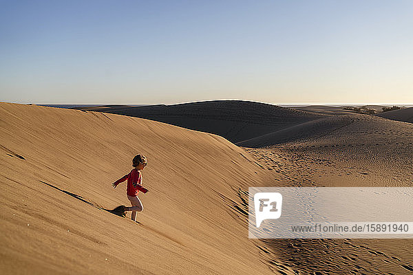Girl running down sand dune  Gran Canaria  Spain