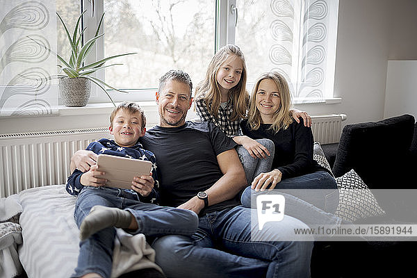 Portrait of happy family relaxing on couch at home