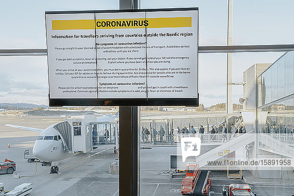 Informationsschild mit Sicherheitsvorschriften bezüglich Coronavirus am Flughafen Oslo  Norwegen