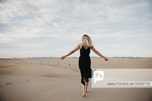 Rückenansicht einer blonden Frau  die barfuss auf einer Sanddüne läuft  Algodones Dunes  Brawley  USA