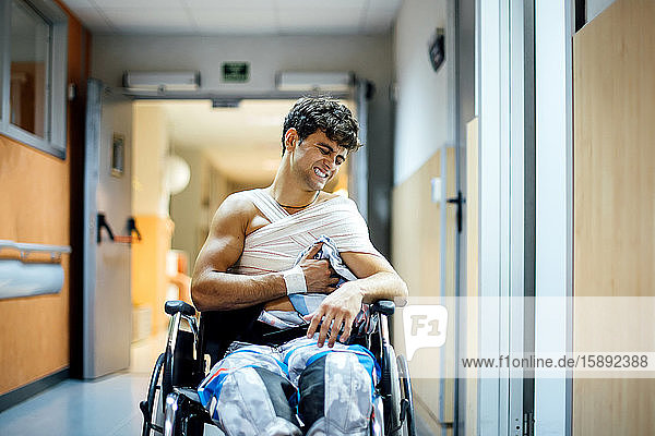 Junger Mann sitzt im Krankenhaus im Rollstuhl